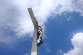 white cross with jesus clouds and sky