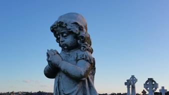 stone sculpture of an angel on a blue background