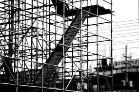 Black and white photo of the construction with stairs, near the buildings