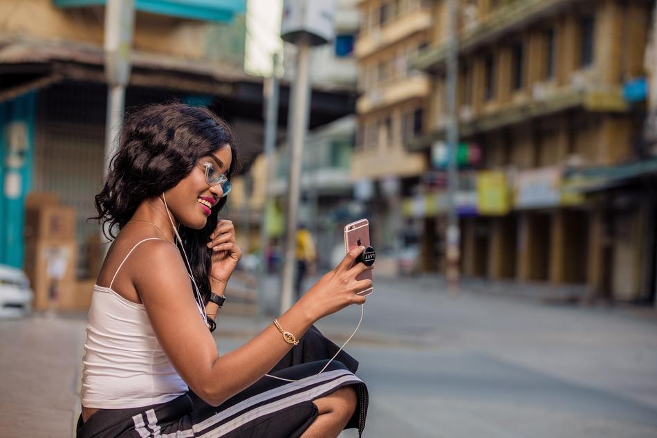 girl with a cell phone by the side of the road