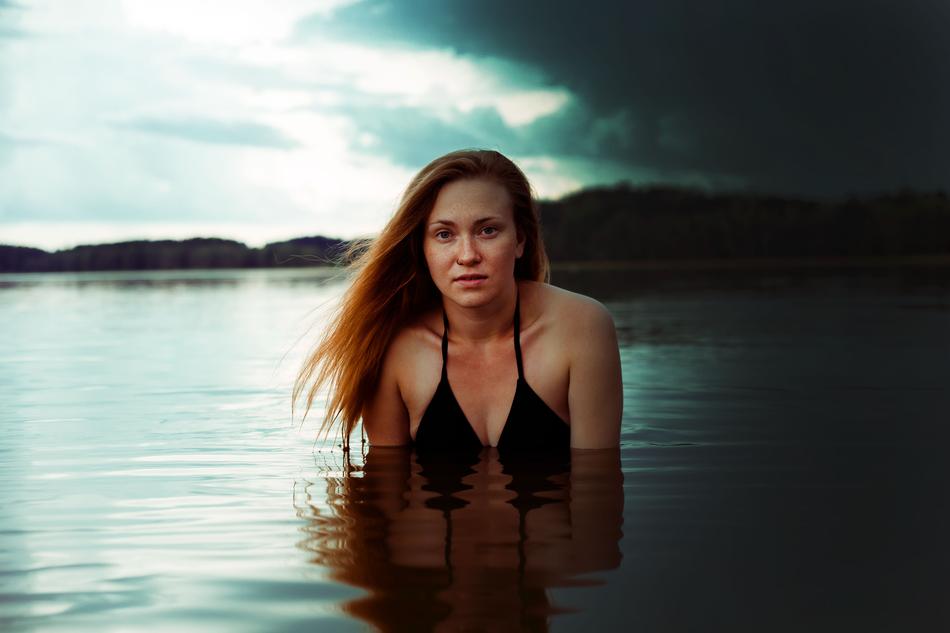 girl in a black bikini in a lake in a storm