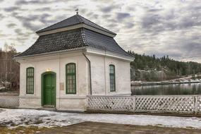 white building with a green door against the background of clouds