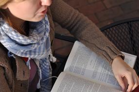 girl is reading a book in the garden