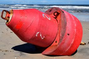 red buoy discarded on the beach