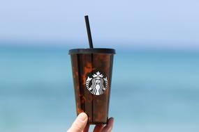 hot coffee from starbucks with the sea in the background