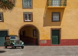 vintage car in front of a yellow house