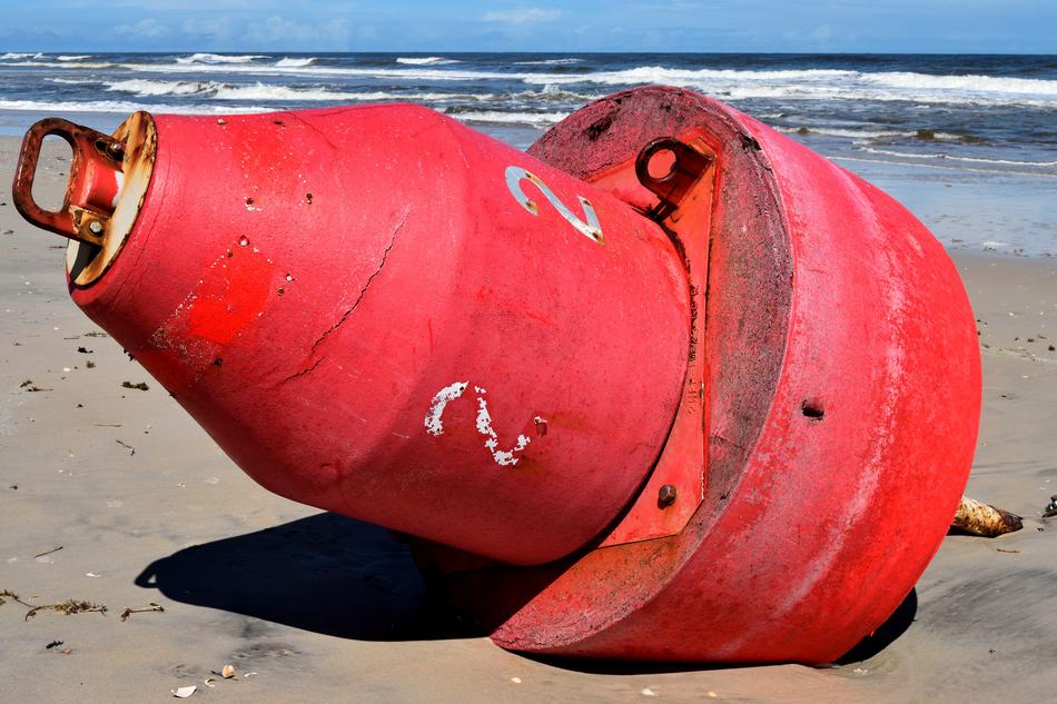 red buoy discarded on the beach