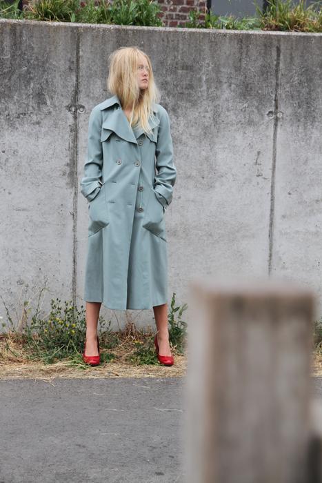 a girl in a blue coat on the street