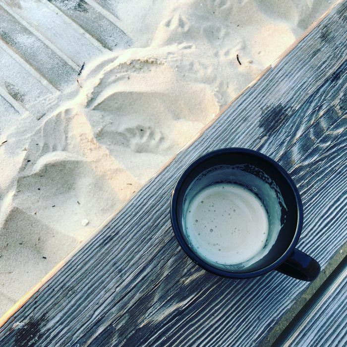 finished mug of coffee on the beach