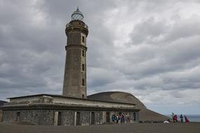 lighthouse on the beach shrouded in clouds