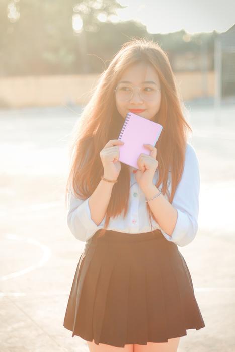Vietnamese schoolgirl with a notepad in her hand