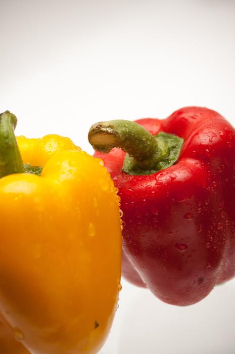 wet colored peppers on a white background