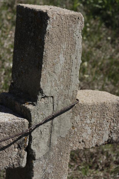 a large stone cross in the meadow