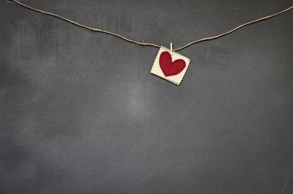 a card with a red heart on a string