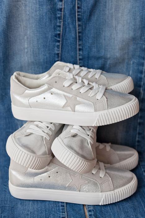 white sneakers on blue jeans