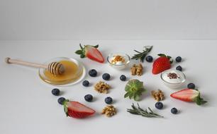 honey and fruit on a white table