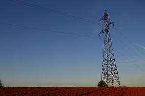 Electricity tower with the wires, on the colorful and beautiful field, at colorful and beautiful sky on background