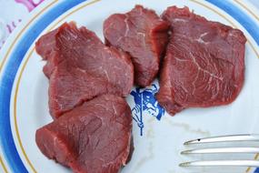 raw red pieces of meat on a plate