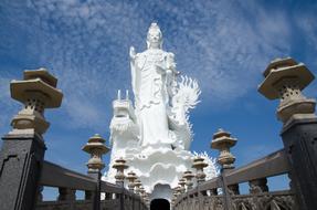 a big white statue in a blue sky.