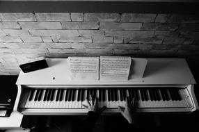 Black and white photo of hands playing on a piano