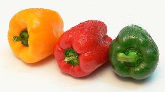 Colored ripe peppers in a drop of water
