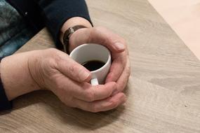 a small cup of coffee with your hands