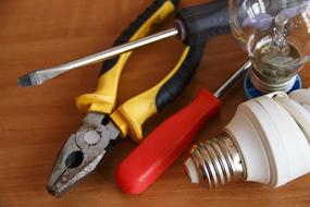 Colorful tools and shiny light bulbs, on the wooden table