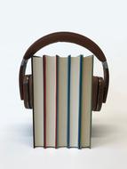 Colorful books with the headphones, with the shadows, on the white surface