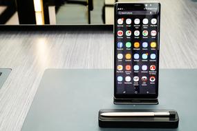 Shiny, black Android smartphone with the colorful icons, on the stand