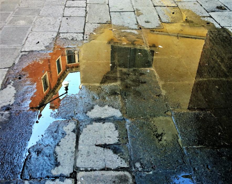 reflection of houses in a puddle of water