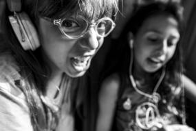 two funny child girls with headphones