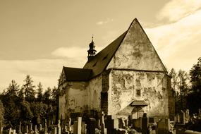 an old house with a cemetery on the background