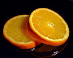 sliced juicy orange on a black background