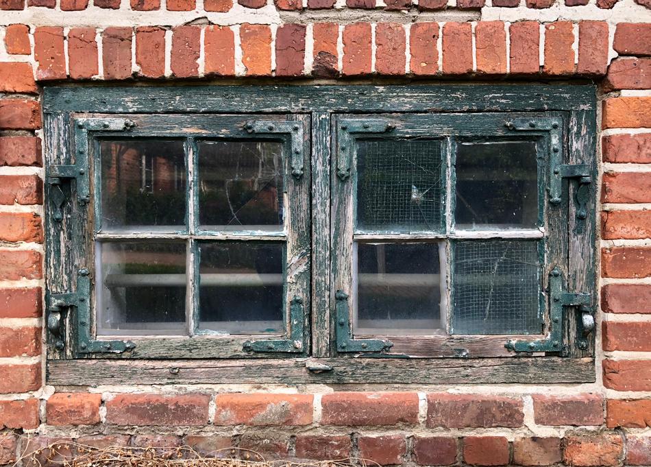 dilapidated window on a brick wall