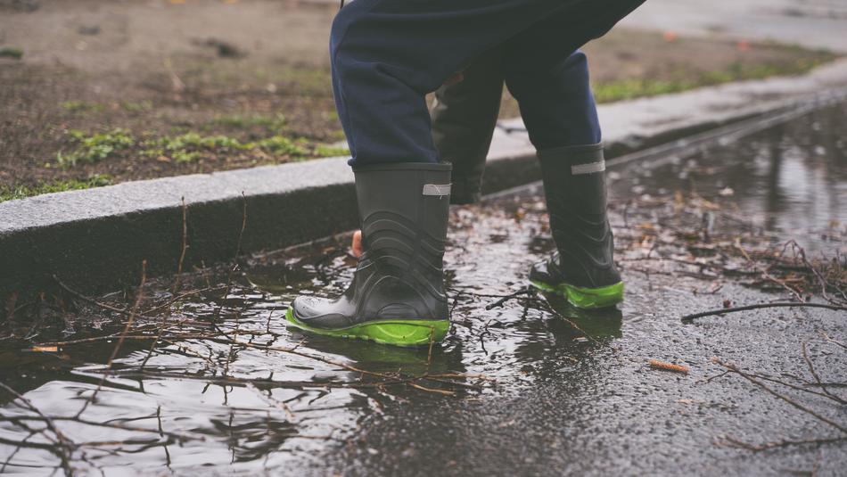 boy in rubber boots in a puddle