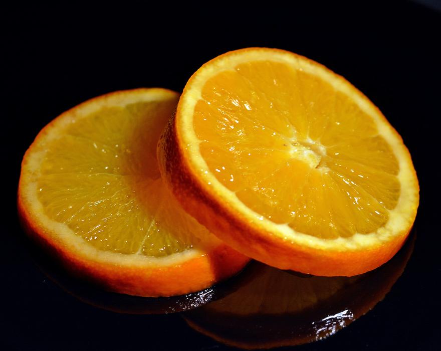 sliced juicy orange on a black background