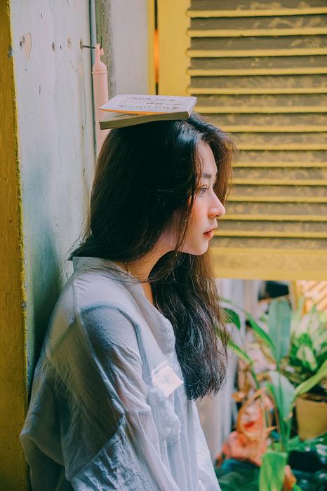 Portrait of Girl model with book on head