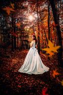 a girl in a white dress in the autumn forest