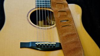 acoustic guitar with leather belt