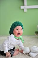 a green hat on a cute baby