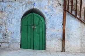 green wooden door in the wall