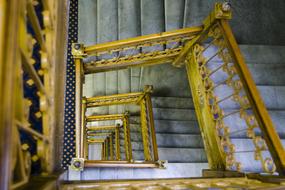 swirling staircase with a golden handrail