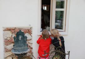 cute kids looking out the window of the house