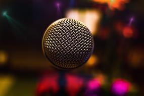 photo of a microphone on a background of night lights