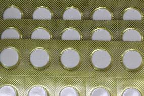 White tablets, in the gold, shiny blister packages