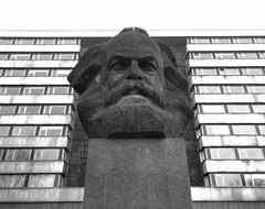 monument to Karl Marx on the background of the city building