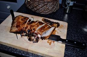 fried sliced meat on a wooden board