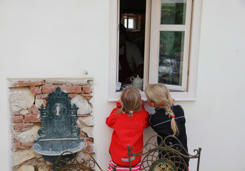 cute kids looking out the window of the house