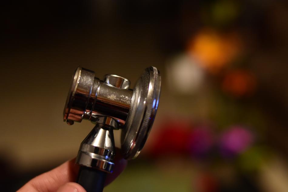 Close-up of the shiny stethoscope in the hand, at blurred background