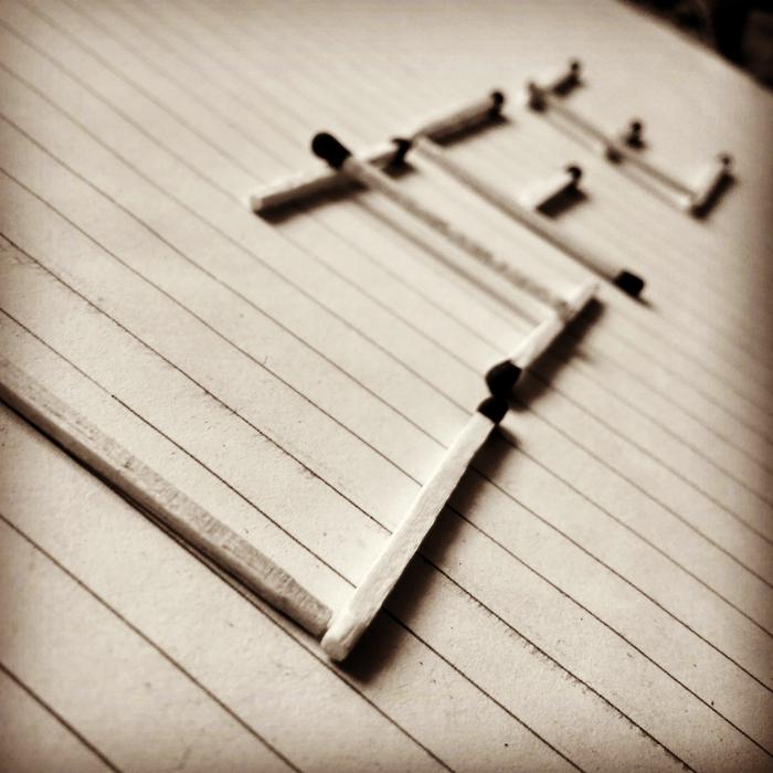 'LIFE' sign, made of the matches, on the wooden surface, in light